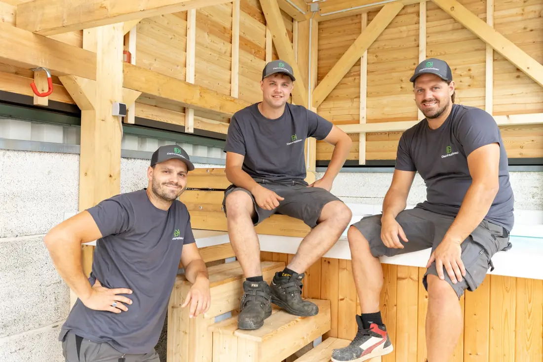 Das Team von DeinHolzbau unter einem fertigen Holztragwerk